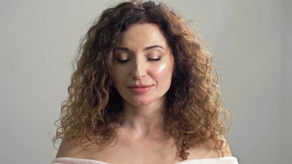 Portrait of a Charming Wellgroomed Middleaged Woman with Brown Curly Hair