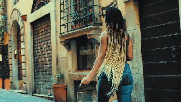 tourism in Rome - beautiful hispanic woman walks in Trastevere looking around