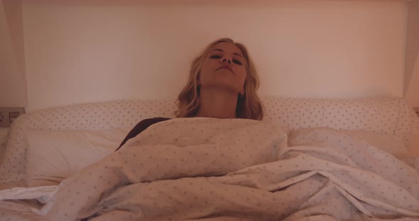 Woman Waking And Sitting Up In Bed