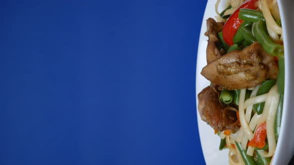 Thai Noodles in a Rotating Plate on a Blue Background