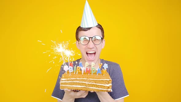 Happy Birthday Concept. Young Funny Man with a Cake o an Orange Background