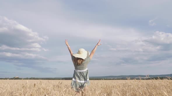 Model Woman in Dress Running on Wheat Field. Beauty Girl Outdoors Enjoying Nature