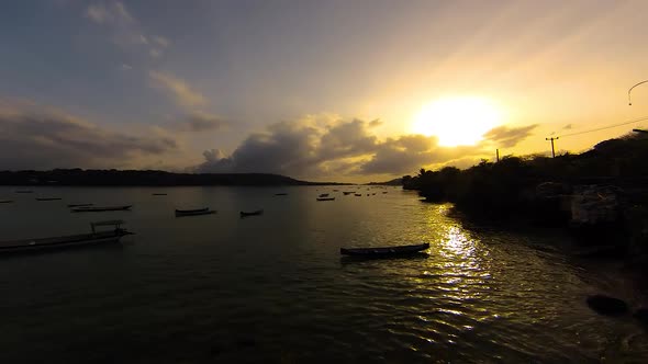 TimeLapse - Sunrise over Ceningan Island (Indonesia), boats bobbing around in ocean straight.