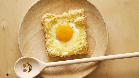 Top View of Toast with Fried Egg and Cheese on Wooden Kitchen Table