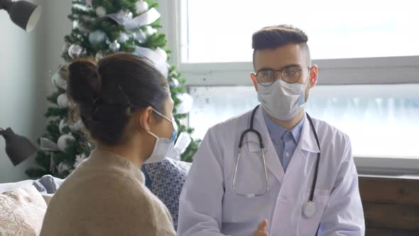 male nurse talking with elderly woman patient, holds hands. Doctor home visit, checking health