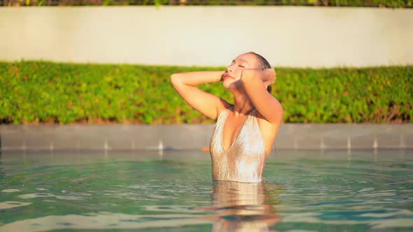 Young asian woman enjoy around outdoor swimming pool for leisure