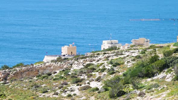 White coastal buildings and blue ocean water near Malta island, static distance view