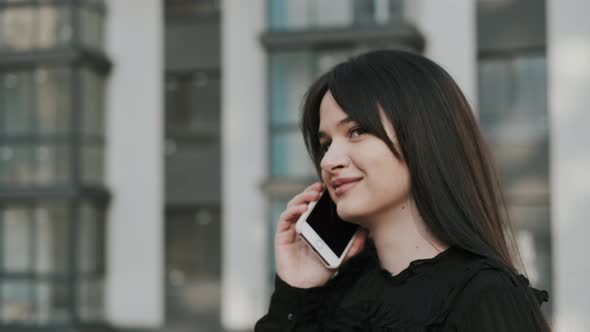 Cute Young Woman Uses Smartphone.