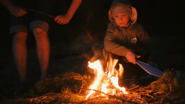 Son and Dad Light a Fire in the Forest. Family Camping