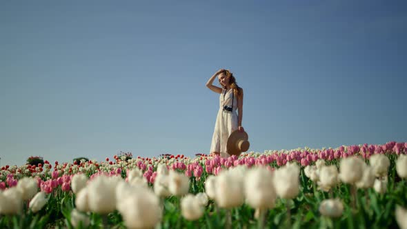 Camera Tracking Around Young Woman with Camera Enjoying Sunny Day in Tulip Field