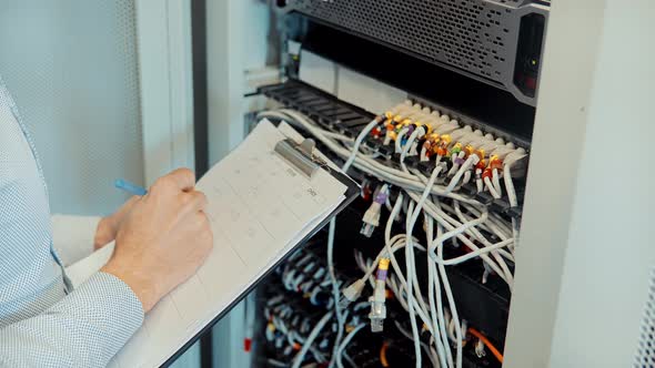 IT Engineer Patching Network Equipment In Server Room. Engineer Come To Server Room For Work.