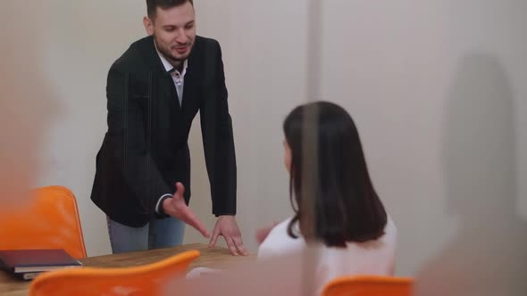 Positive Handsome Businessman Shaking Hands with Brunette Businesswoman and Leaving Glass Office