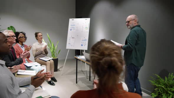 Mature Business Coach Entering Training Room and Greeting People