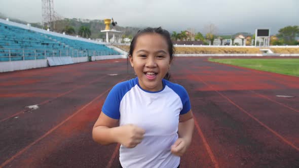 Front View Of Little Girl Running At Stadium