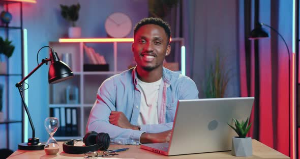 African American Poses on Camera at His Workplace with Computer