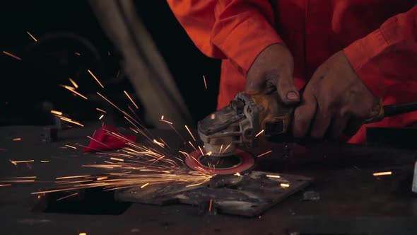 Professional mechanic is cutting steel metal.