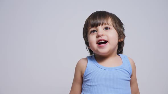 Baby Boy in Blue T-shirt and Gray Shorts Jumping