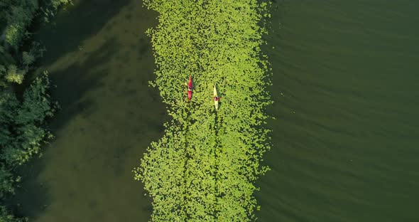 Two kayaks are sailing along a scenic river. Aerial view.