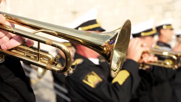 A Wind Instrument  a Unrecognizable Military Man is Playing Trumpet Closeup