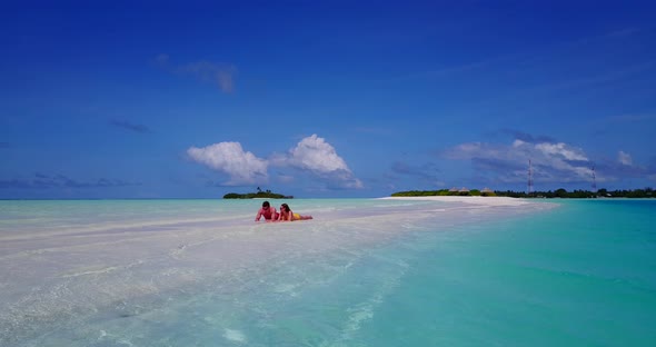 Beautiful man and woman on romantic honeymoon enjoy luxury on beach on sunny white sandy 4K background