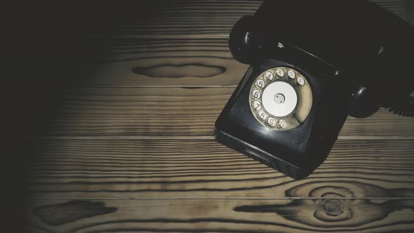 Old Classic Rotary Black Telephone on Brown Wooden Table