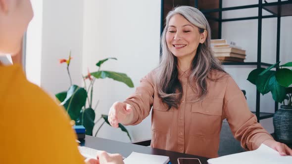 Smiling Mature Asian Female Manager Handshake