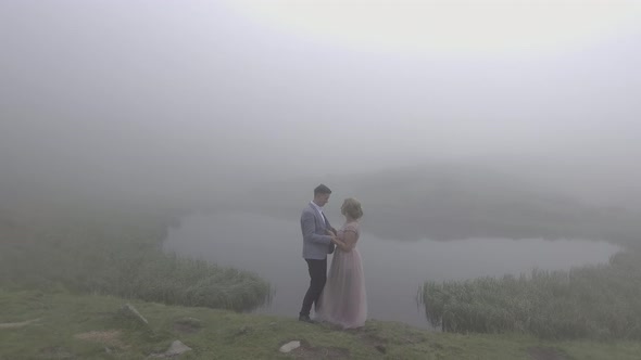 Elegant couple standing by a lake 