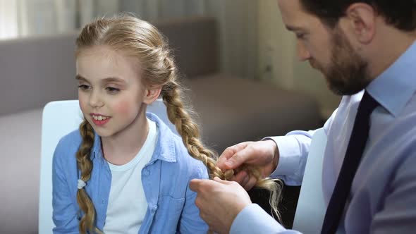 Single Father Braiding Daughter Hair in Morning Before School, Family Time