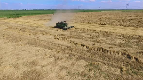 Combine harvester on field. Drone pulls away