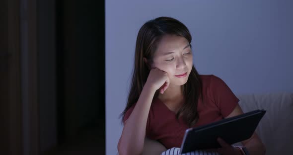 Woman use of tablet computer at night