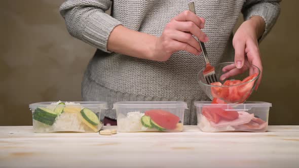 Young woman on a diet distributes fresh healthy food into containers