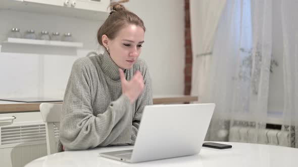 Young Woman Thinking and Working on Laptop at Home