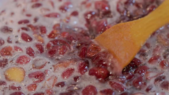 Wooden Spoon Stirring Boiling Domestic Cherry Jam  Fullframe Closeup
