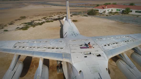 Aerial view woman doing exercise in the top of cargo airplane on Umm Al Quwain.