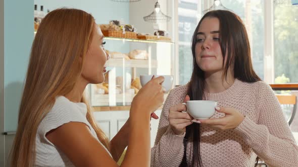 Happy Female Friends Smiling To the Camera, While Having Coffee Together