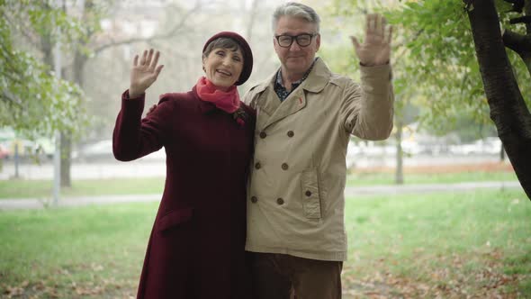 Happy Elegant Senior Couple Looking at Camera and Waving. Portrait of Cheerful Smiling Caucasian