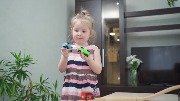 Little Girl Plays with Wooden Toy Railway