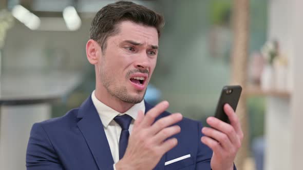 Upset Young Businessman Having Loss on Smartphone 