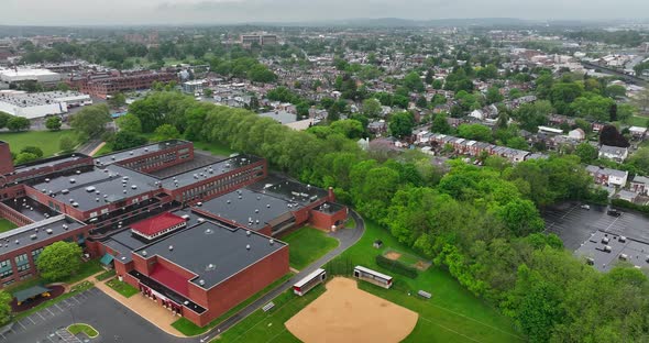 Aerial reverse view of Lancaster city and high school. Rainy day in spring. School provides educatio