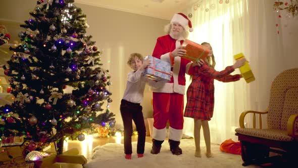 Relaxed Joyful Children and Santa Dancing in Living Room Looking at Camera