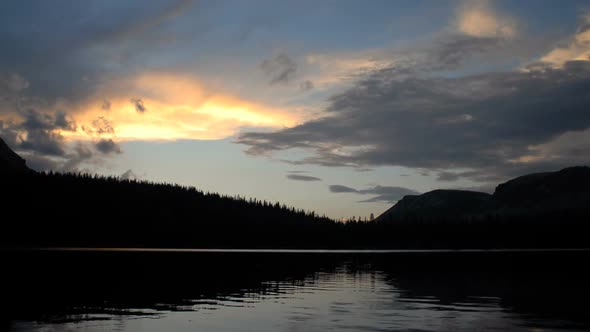 Time-lapse of a mountain lake and clouds at sunset