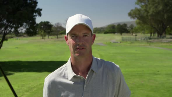 Caucasian male golfer smiling at camera on a golf course