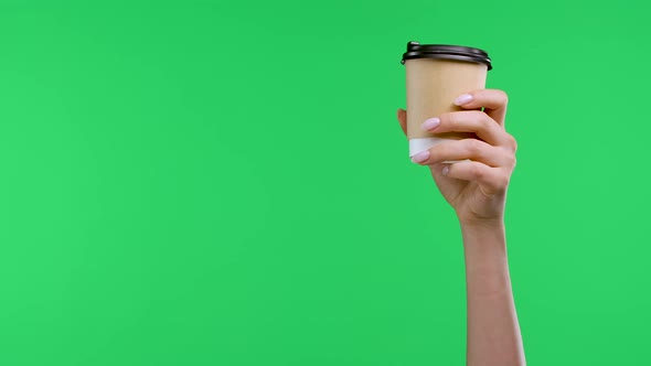 A Woman's Hand Holds a Paper Cup with Coffee the Other Hand Points the Index Finger at the Coffee