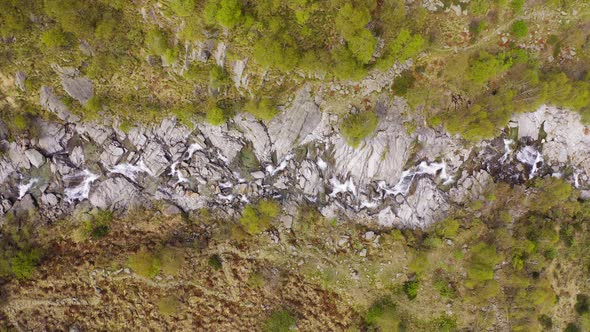 Aerial View of Waterfall Flowing Trough Rocks of Mountain