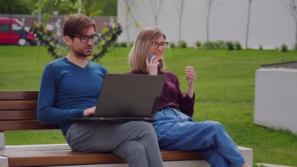 Man wearing glasses working on laptop computer.