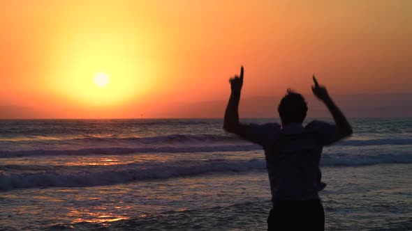 Excited Man Celebrating at Beach and Jumping with Joy