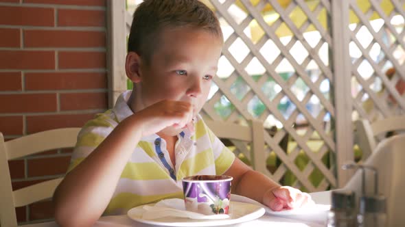 Child Eating Chocolate Ice Cream in Cafe