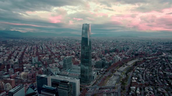 Dolly in aerial view of the financial center of Santiago, Chile. Orange cloudy sunset in the backgro