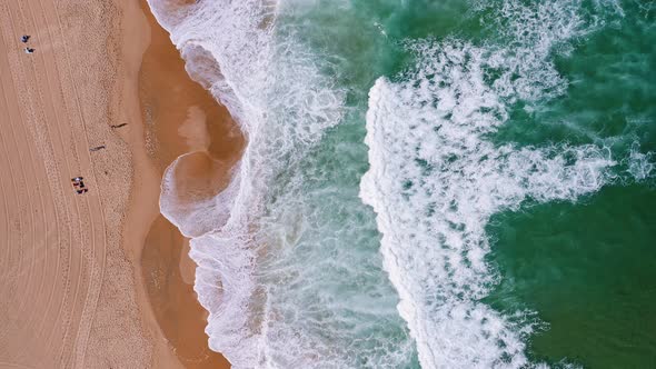 Top Aerial View of Waves Break on Tropical Yellow Sand Beach