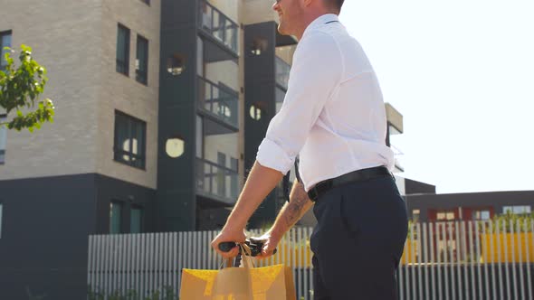 Businessman with Takeaway Lunch Riding Scooter